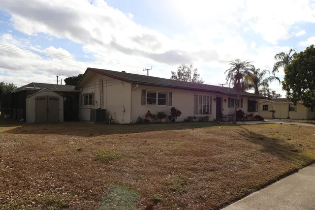 a view of a house with backyard and a tree