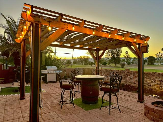 1395 Lause Road Bullhead City, AZ 86442 - Photo 27 of 34 Outdoor living area featuring a wood pergola with string lighting, paver patio, built-in fire pit