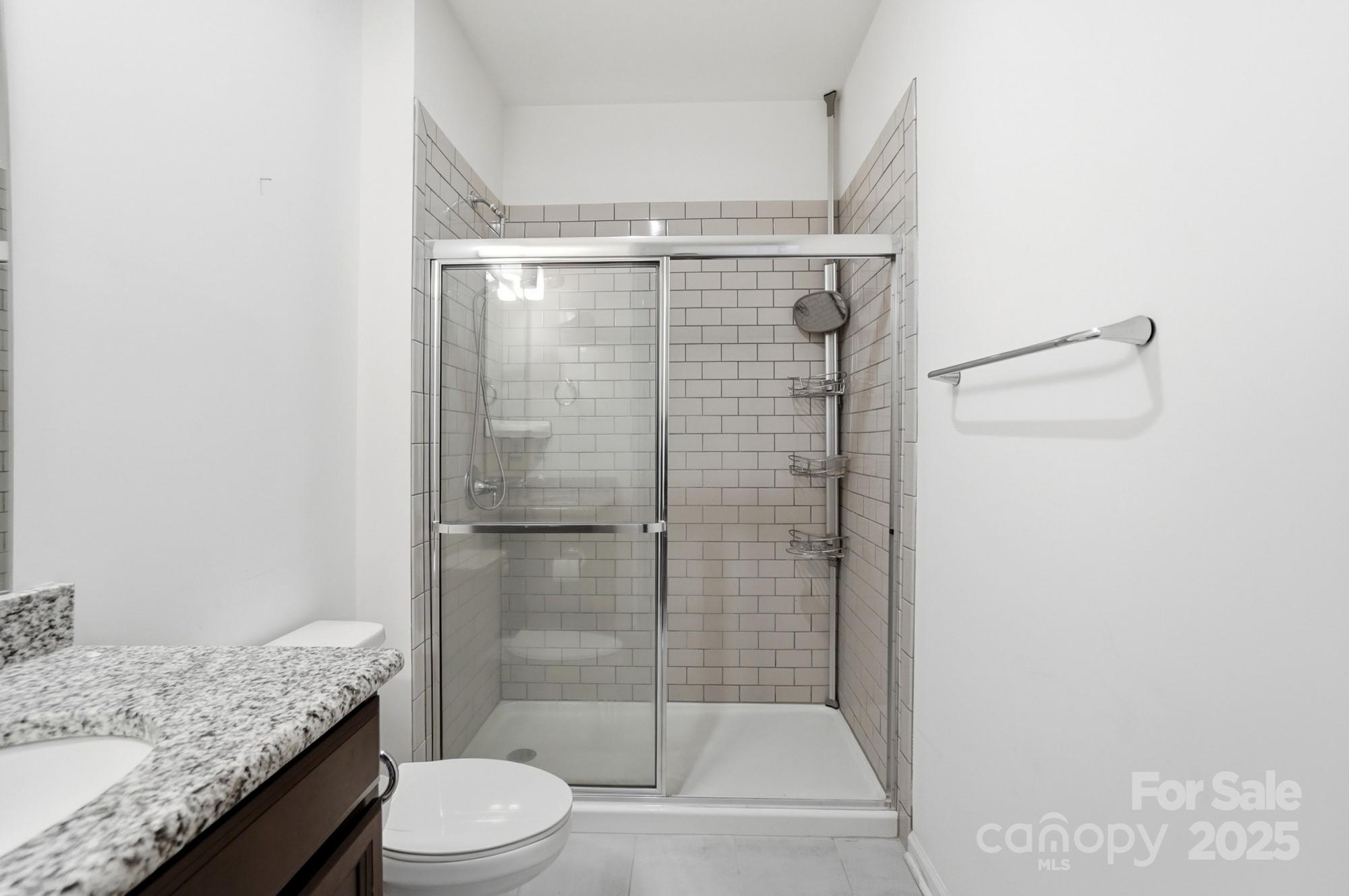 4325 Hunton Dale Road Northwest Concord, NC 28027 - Photo 18 of 42 a bathroom with a granite countertop sink toilet and shower
