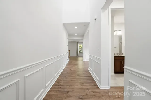 a view of a hallway with wooden floor and staircase