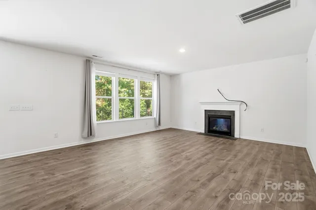 a view of empty room with wooden floor and fireplace