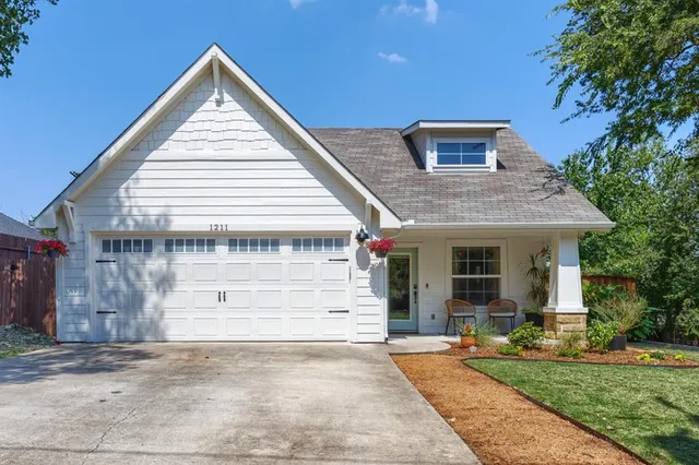 a view of a white house with a large windows and a yard