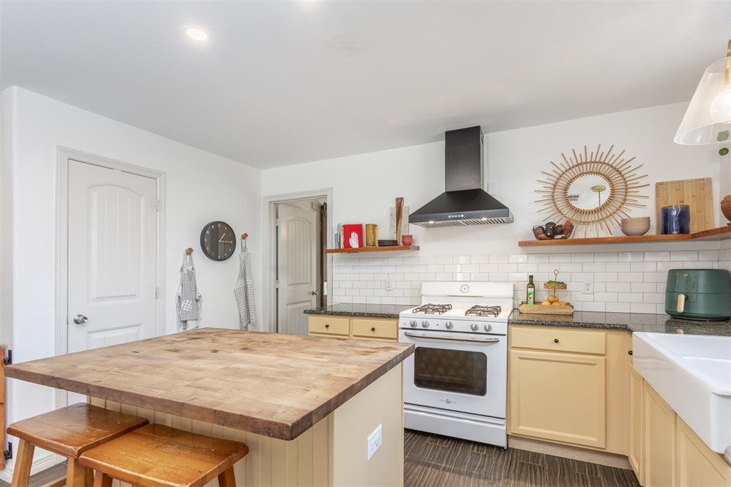 1211 Garcia Street McKinney, TX 75069 - Photo 11 of 27 a kitchen with a stove and a white refrigerator