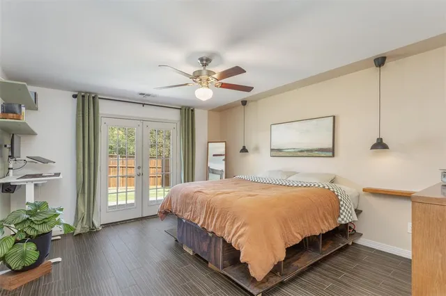 a bedroom with a large bed a chandelier and windows