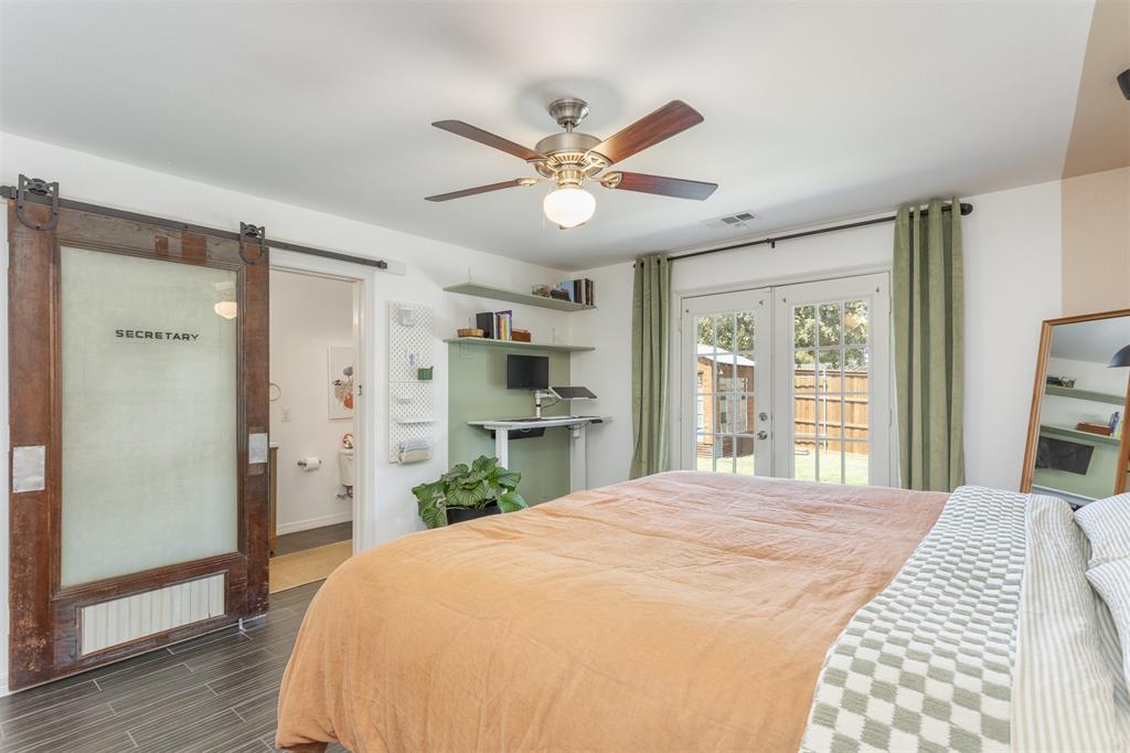 1211 Garcia Street McKinney, TX 75069 - Photo 13 of 27 a bedroom with a large bed and a chandelier