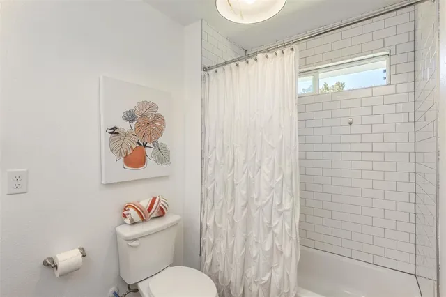 a white toilet sitting next to a shower curtain