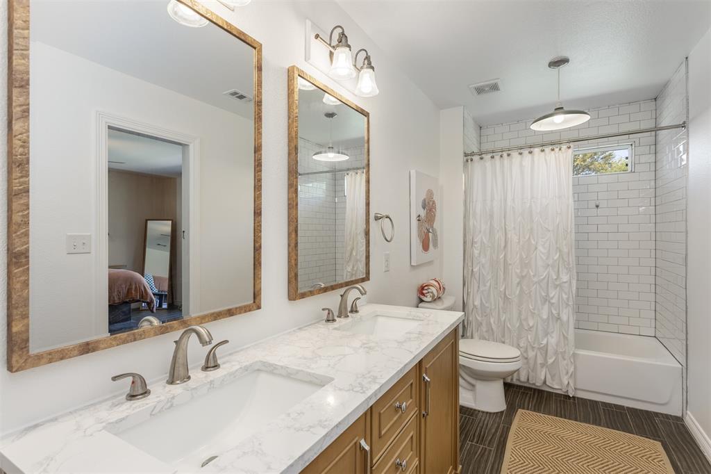 1211 Garcia Street McKinney, TX 75069 - Photo 16 of 27 a bathroom with a granite countertop sink a toilet a mirror a shower and a bathtub
