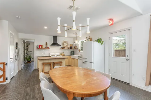 a room with kitchen island a wooden floor and white appliances
