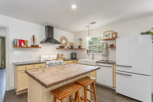a kitchen with a stove a refrigerator and a sink