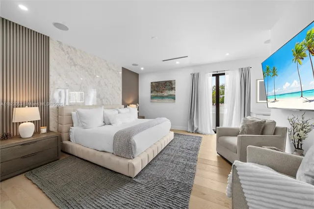 a large white bedroom with a bed and couch