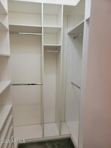 a view of walk in closet with empty racks