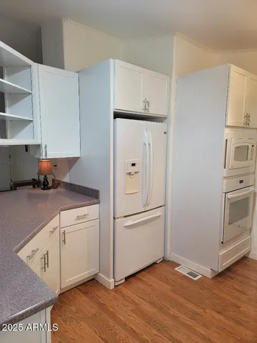 a kitchen with cabinets and wooden floor
