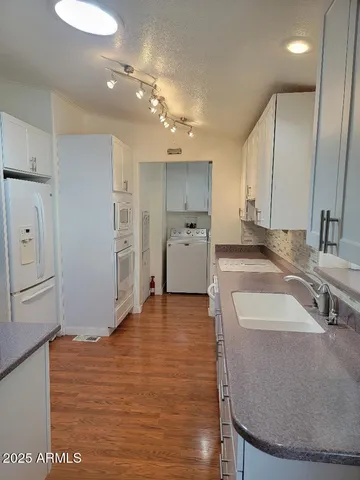 a large kitchen with a sink a refrigerator and a stove