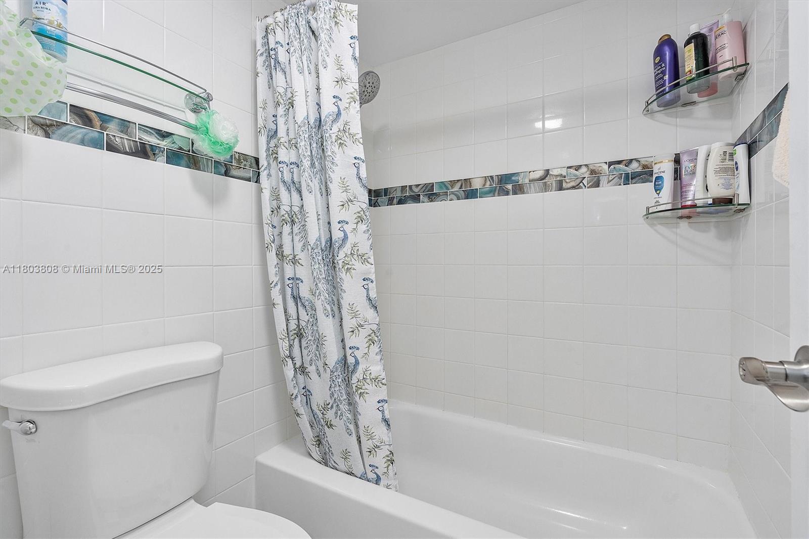 9511 Collins Avenue, Unit 1002 Surfside, FL 33154 - Photo 13 of 27 a bathroom with a shower a toilet and sink