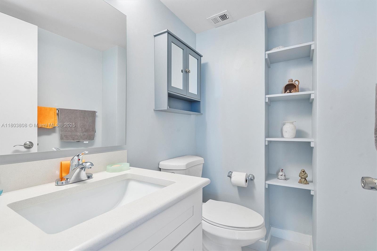 9511 Collins Avenue, Unit 1002 Surfside, FL 33154 - Photo 14 of 27 a bathroom with a sink a toilet and vanity