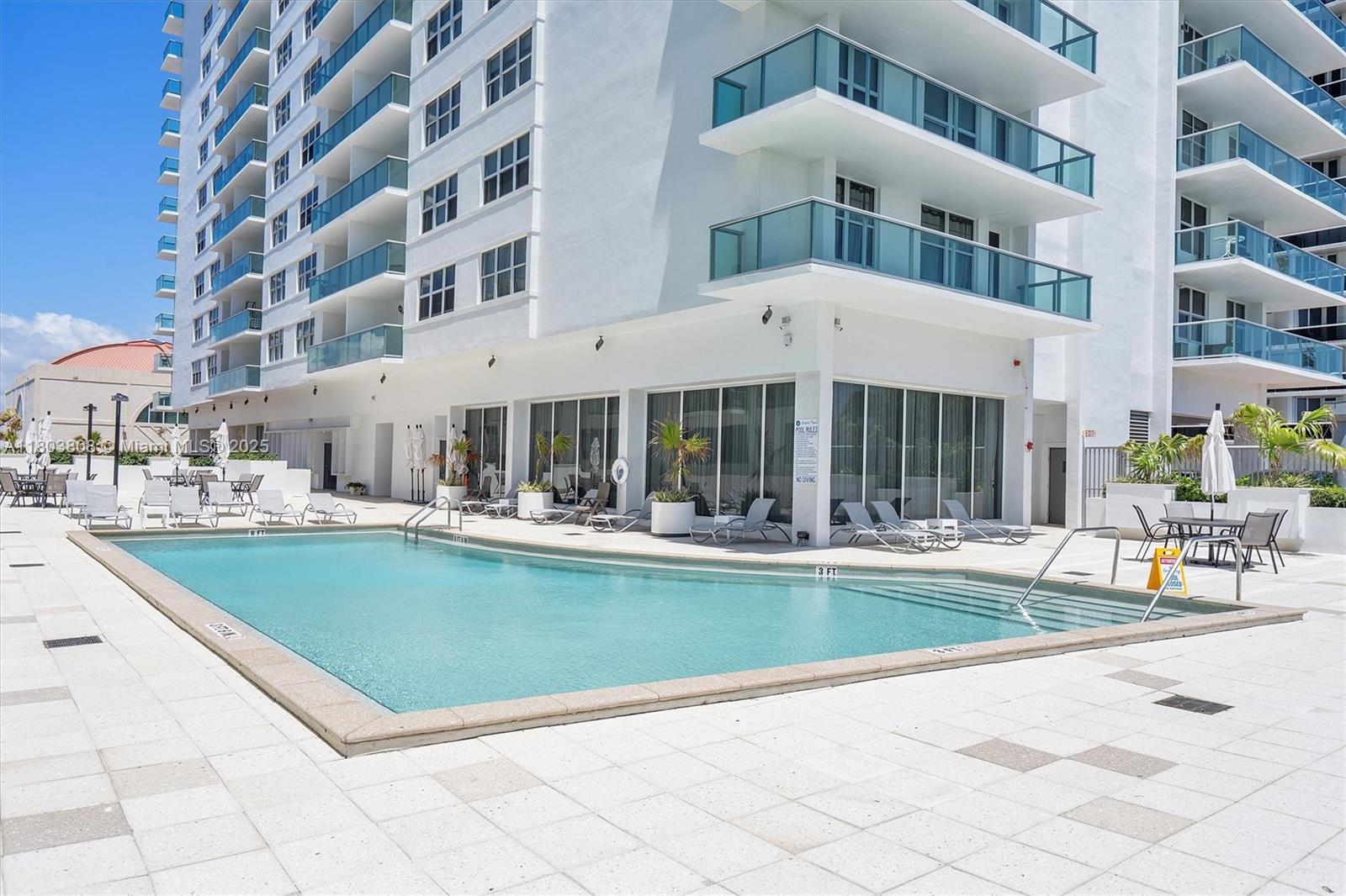 9511 Collins Avenue, Unit 1002 Surfside, FL 33154 - Photo 18 of 27 a view of a building with a swimming pool and sitting area