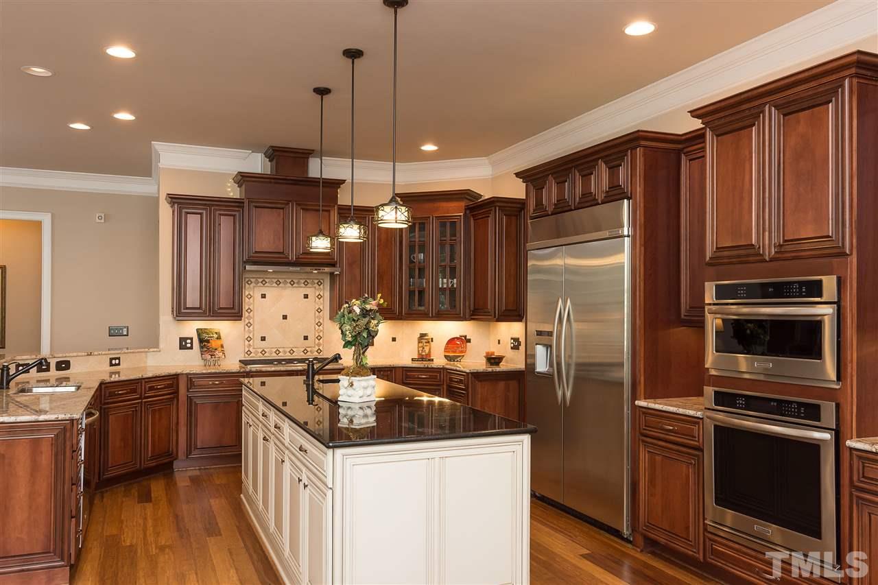 3929 Colinwood Lane Raleigh, NC 27606 - Photo 2 of 24 a kitchen that has a sink a kitchen island stainless steel appliances and cabinets