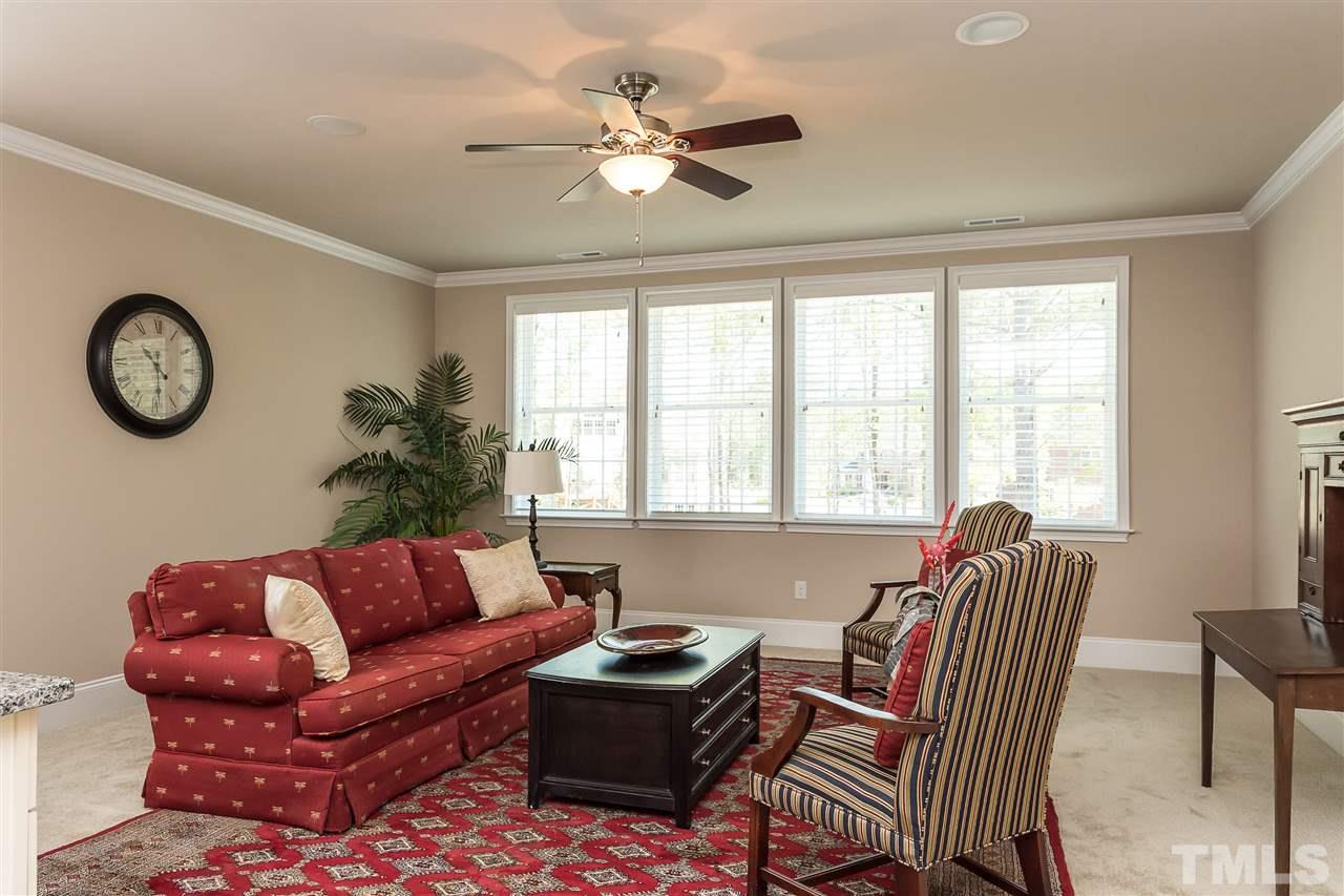 3929 Colinwood Lane Raleigh, NC 27606 - Photo 18 of 24 a living room with furniture a clock and a large window
