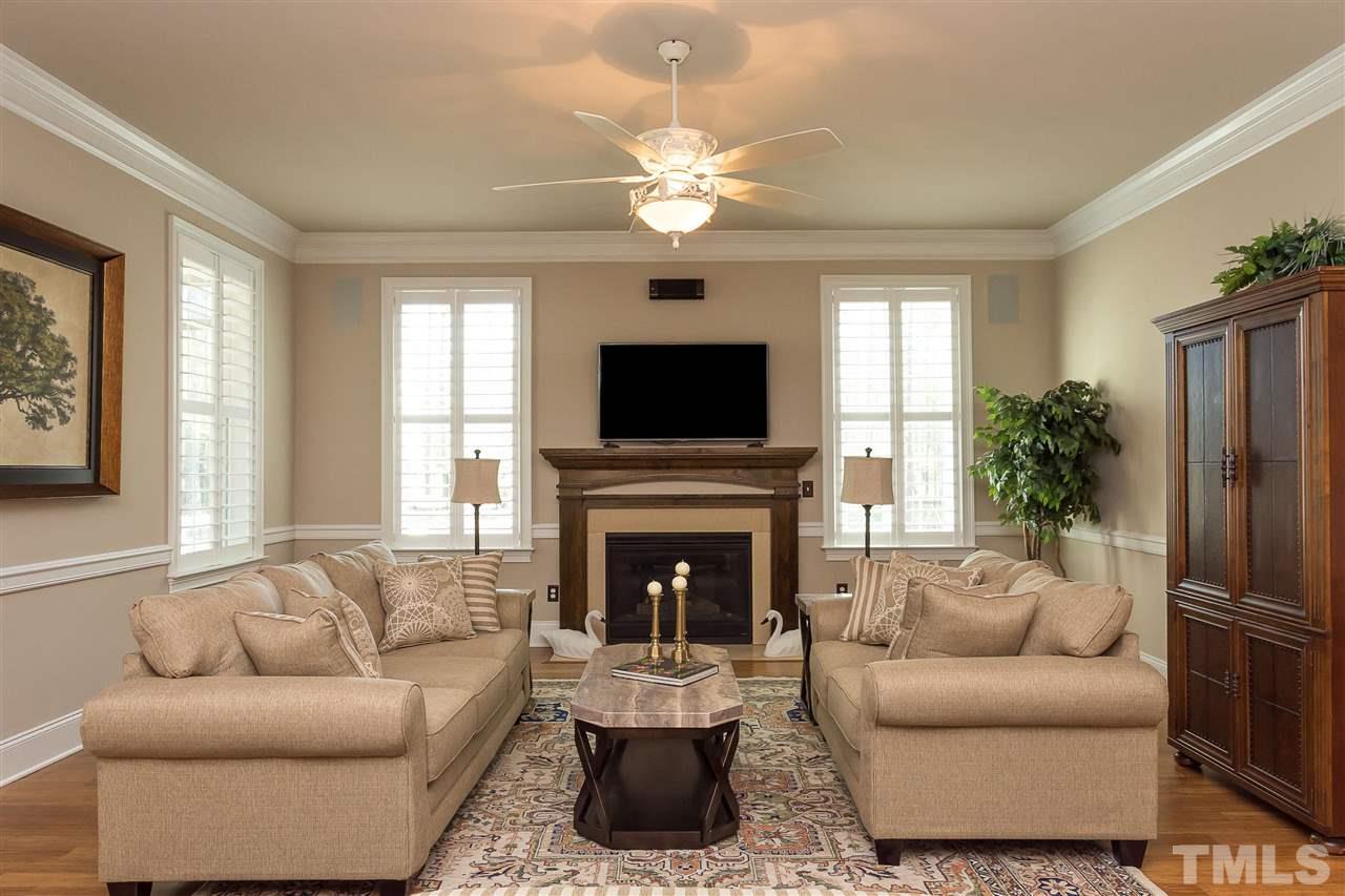 3929 Colinwood Lane Raleigh, NC 27606 - Photo 6 of 24 a living room with furniture a fireplace and a flat screen tv