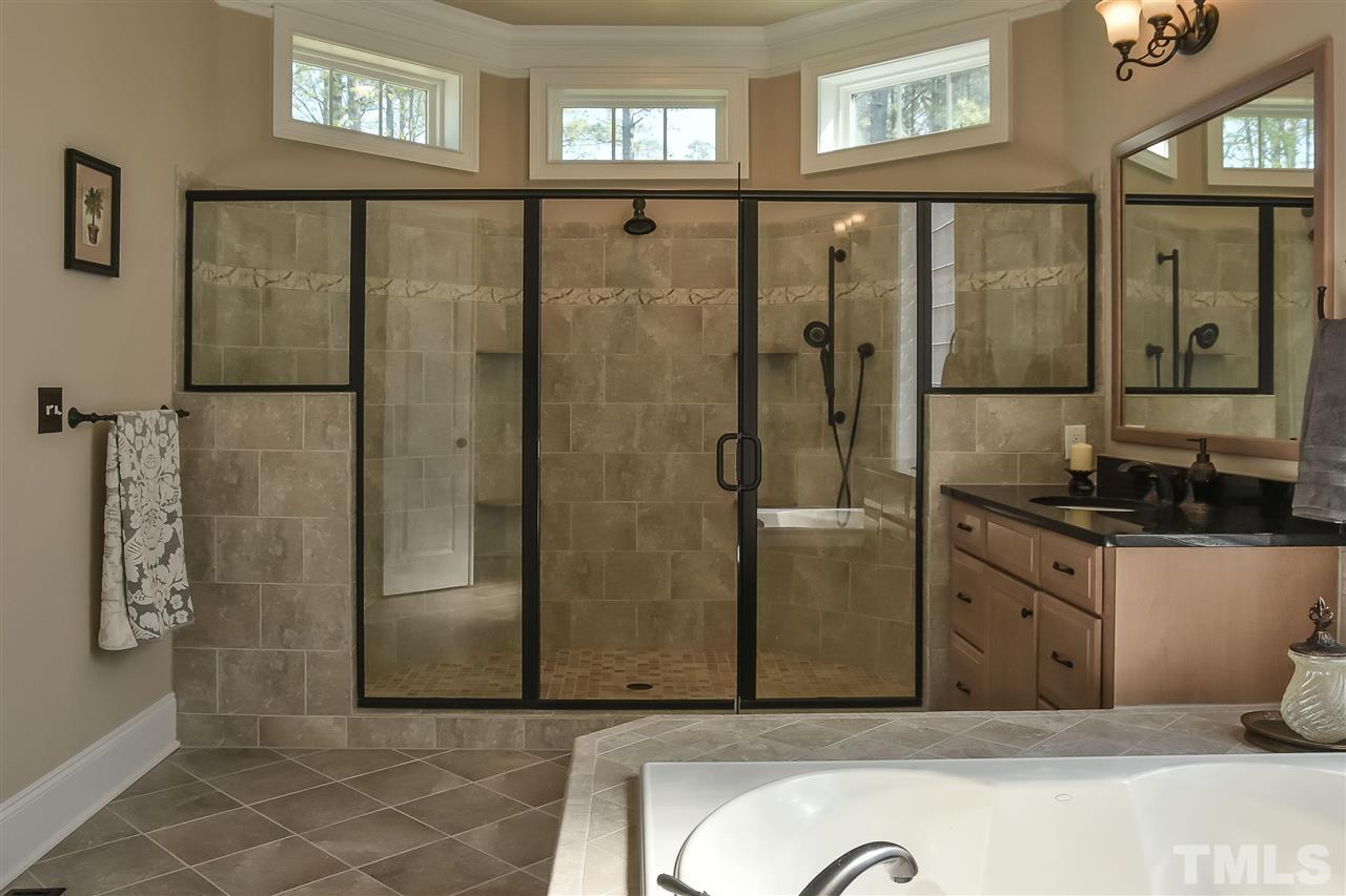 3929 Colinwood Lane Raleigh, NC 27606 - Photo 10 of 24 a bathroom with a granite countertop tub sink shower and mirror