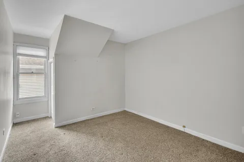 a large kitchen with cabinets a sink a window and stainless steel appliances