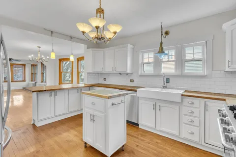 a large kitchen with stainless steel appliances granite countertop a sink and cabinets