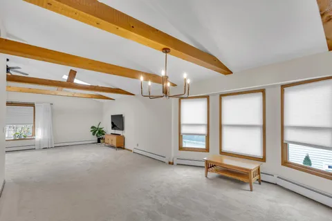 a kitchen with stainless steel appliances a refrigerator a stove a sink and a dining table with wooden floor