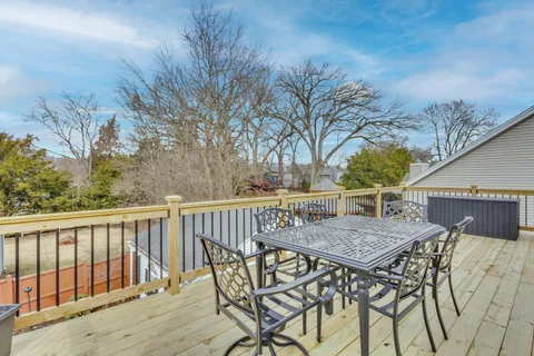 a view of a roof deck with wooden fence and trees