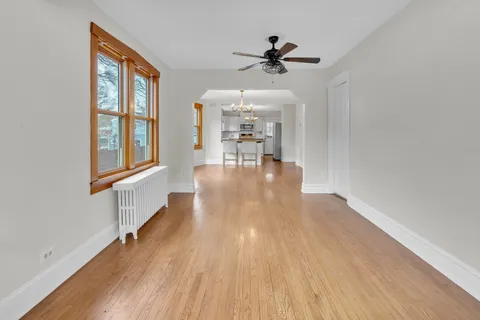 a kitchen with stainless steel appliances granite countertop a stove top oven a sink dishwasher and a dining table with wooden floor