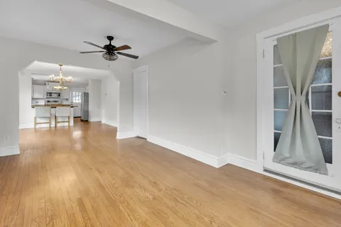 a view of an empty room with window and wooden floor