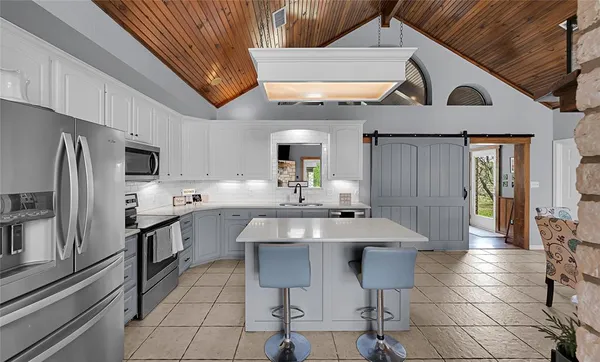 a kitchen with stainless steel appliances a sink a stove a refrigerator and cabinets