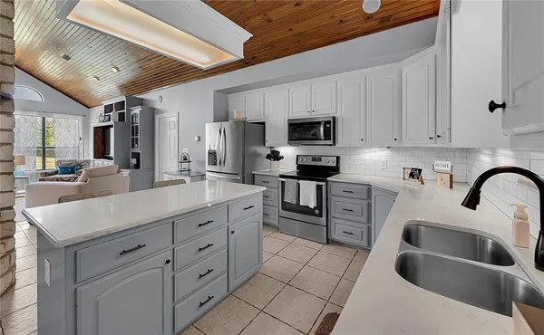 a kitchen with stainless steel appliances a sink a stove top oven a counter space and cabinets