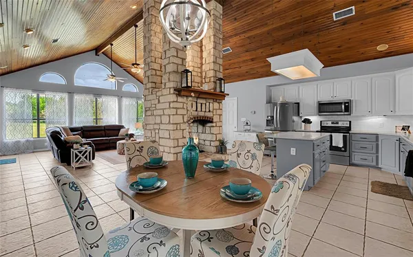 a kitchen with sink a stove and chairs