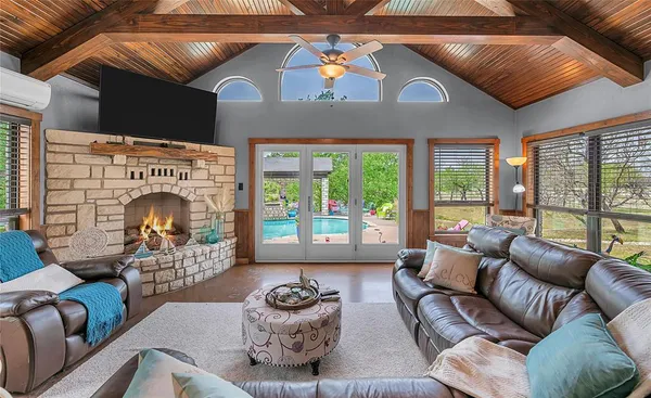a living room with furniture a fireplace and a floor to ceiling window