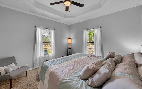 a bed sitting in a bedroom next to a window and a chandelier