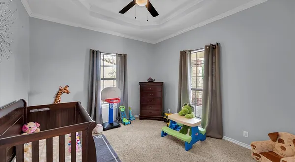 a living room with furniture a baby crib and a window