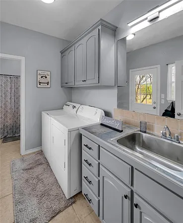 a utility room with sink dryer and washer