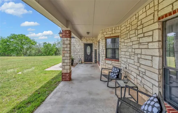 a view of a porch with chairs and backyard
