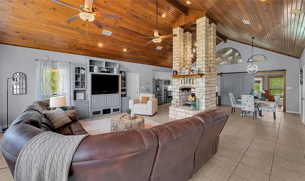 a living room with furniture a flat screen tv and kitchen view
