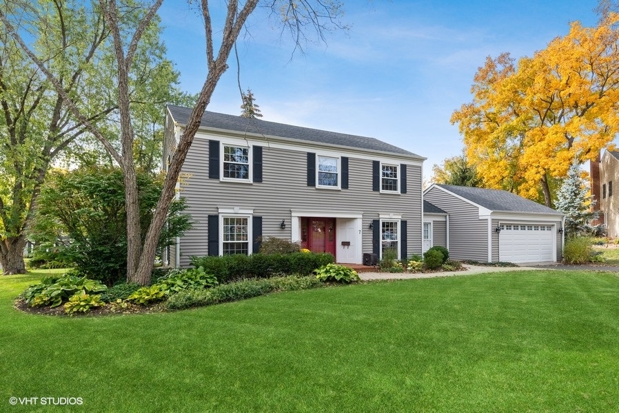 a front view of a house with a yard and trees