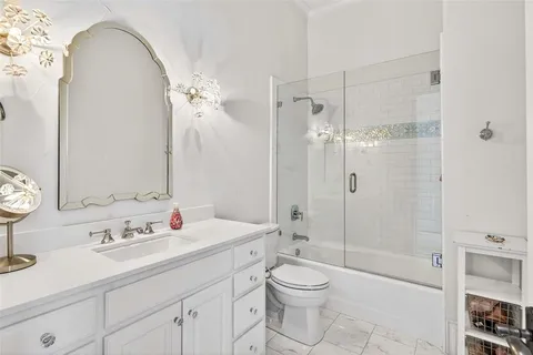 a bathroom with a sink a toilet and a large mirror