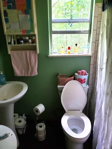 a bathroom with a toilet sink and mirror