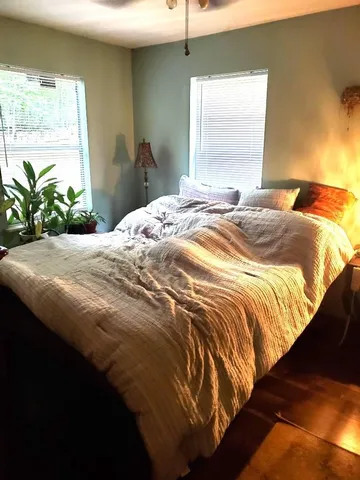 a bedroom with a bed and a large window