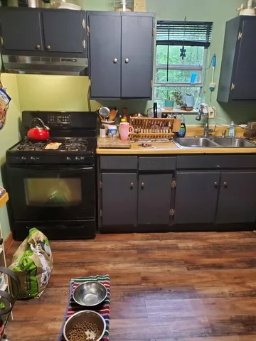 a kitchen with a wooden floor and a fireplace