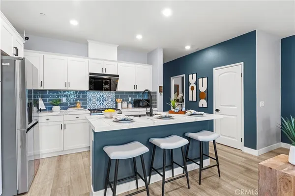 a kitchen with a dining table chairs and refrigerator