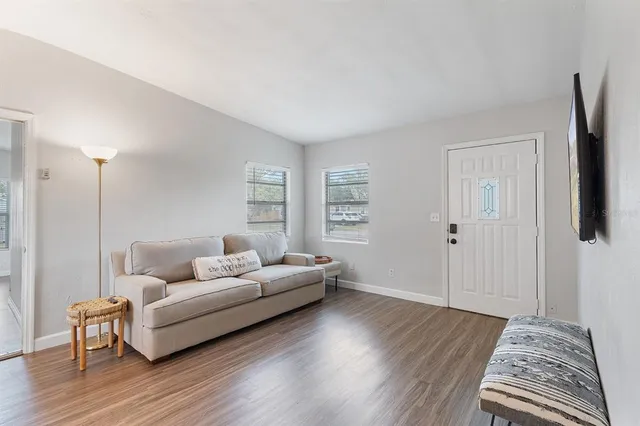 a living room with furniture and a wooden floor