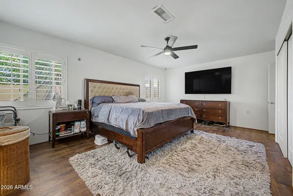 a bedroom with a bed a flat screen tv and window