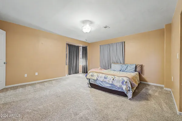 a spacious bedroom with a bed and a cabinets