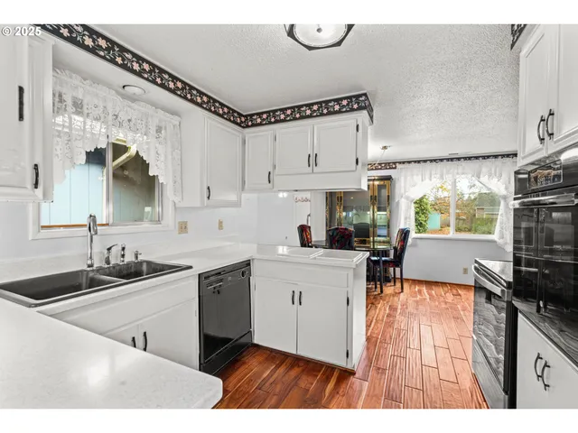 a kitchen with granite countertop a sink stainless steel appliances and cabinets
