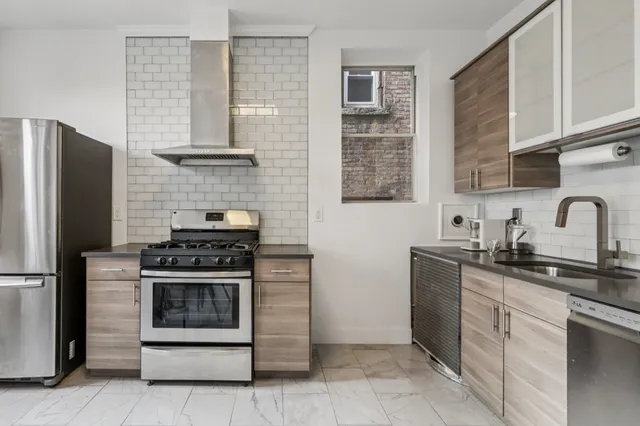 a kitchen with stainless steel appliances granite countertop a stove sink and refrigerator